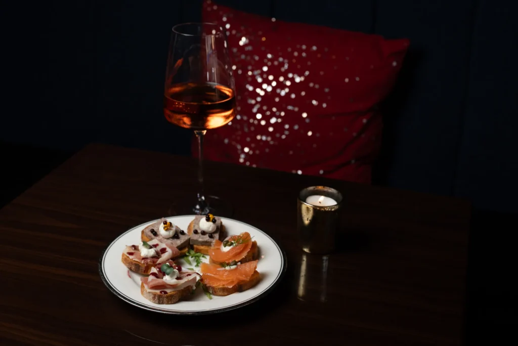 Glass of rosé paired with Vinicola's signature crostini sampler in the wine bar lounge.